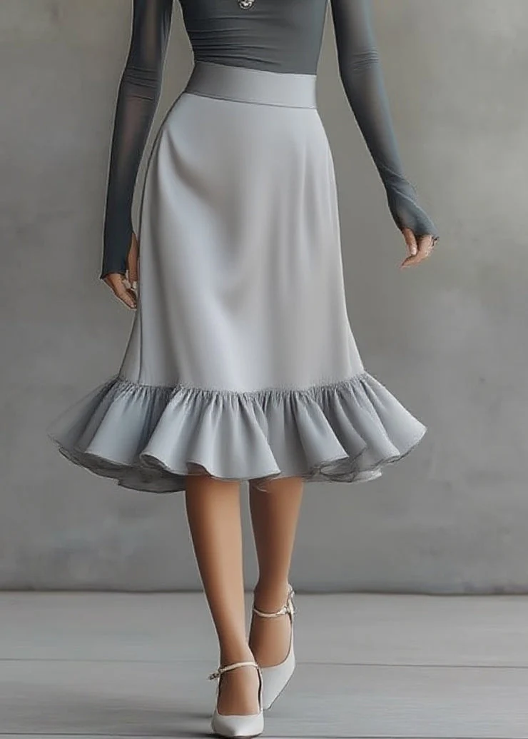 Conjunto compuesto por un vestido midi gris con top de hombros al aire, manga larga y bajo con volantes