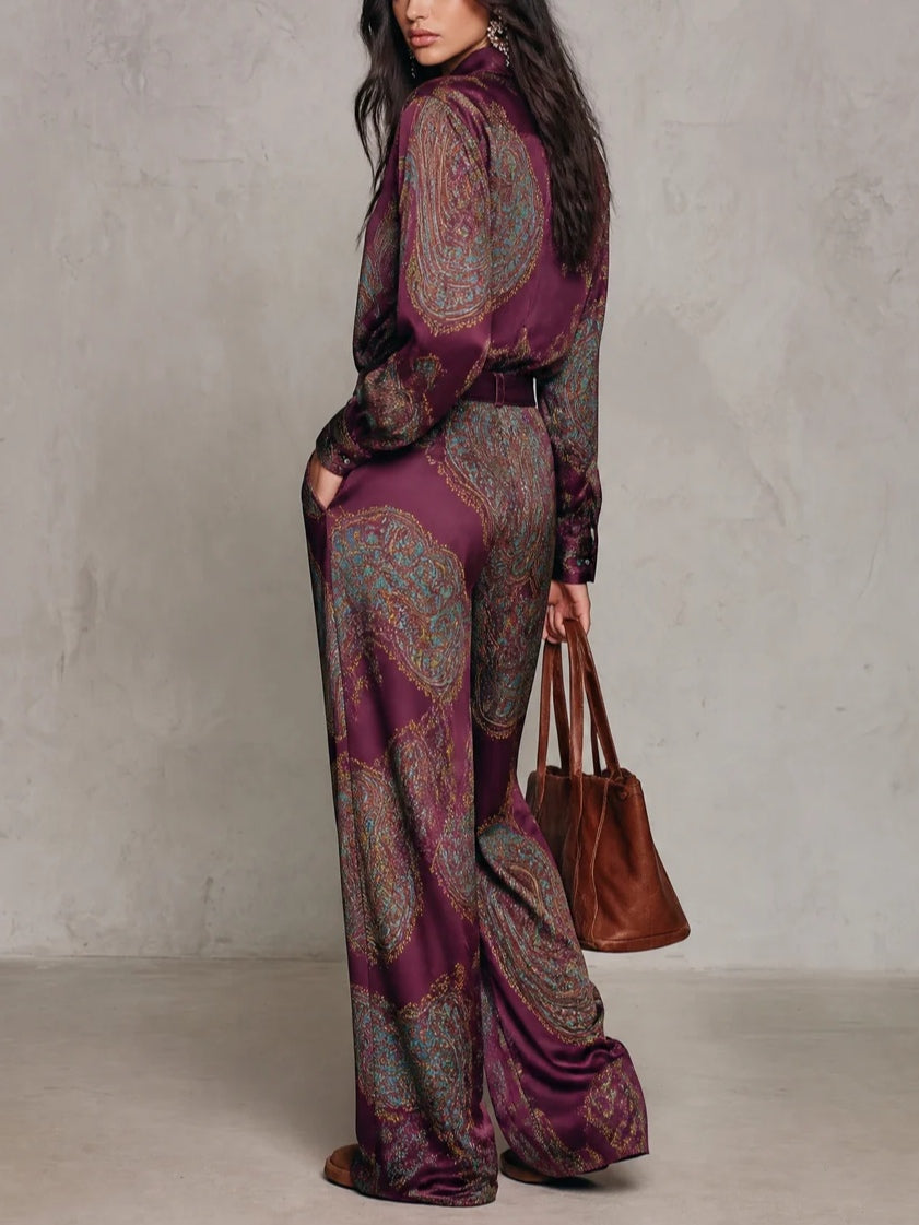 Conjunto compuesto por una camisa de manga larga de satén con estampado de paisley en tonos burdeos y morado, y unos pantalones de pierna ancha