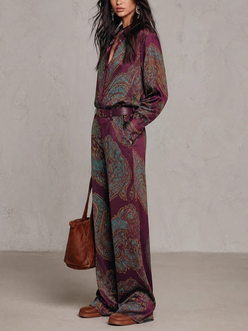 Conjunto compuesto por una camisa de manga larga de satén con estampado de paisley en tonos burdeos y morado, y unos pantalones de pierna ancha